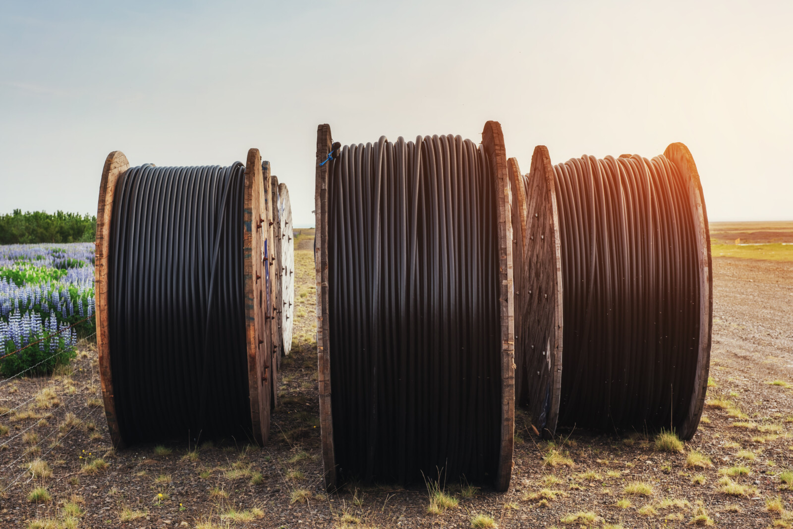 Spools of cable resting outdoors in a rural landscape after utility or infrastructure work and ready for direct sale
