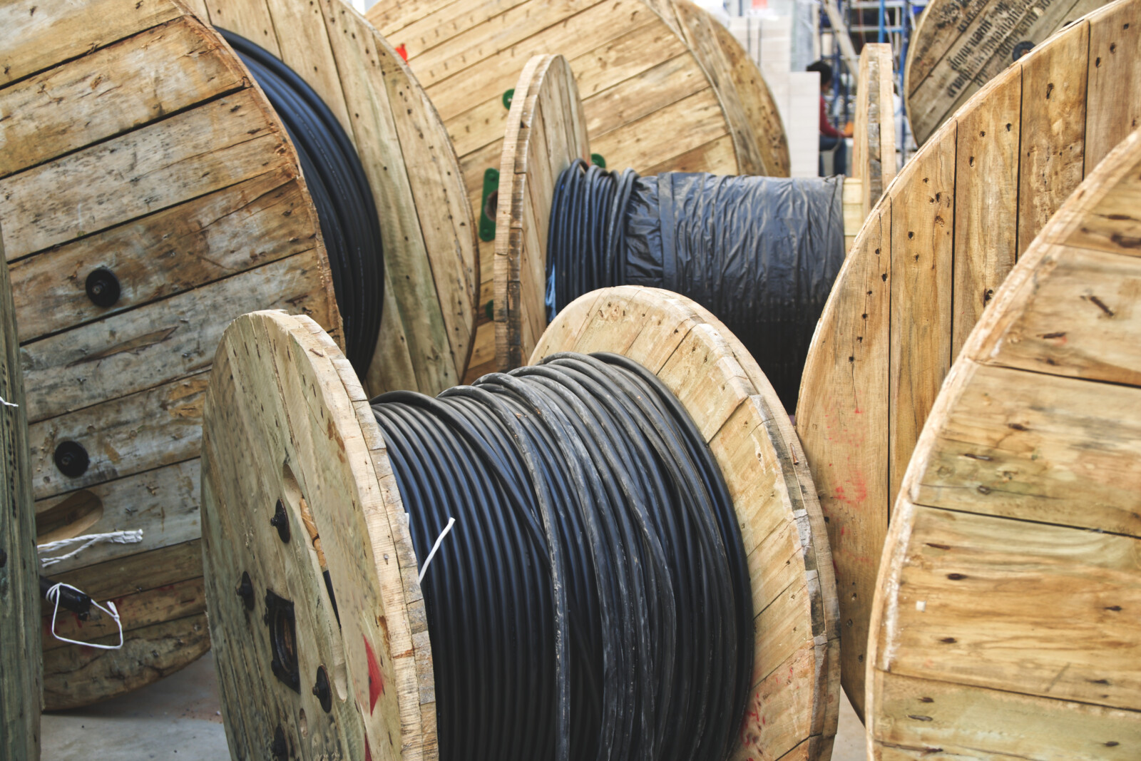 Wooden spools with cable in a factory representing warehouse copper wire reels and organized surplus spool inventory